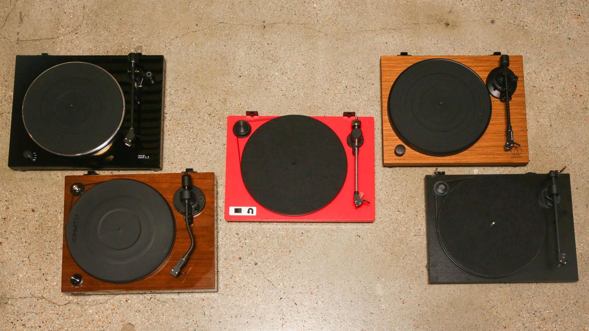 Five different turntables arranged on the floor. 